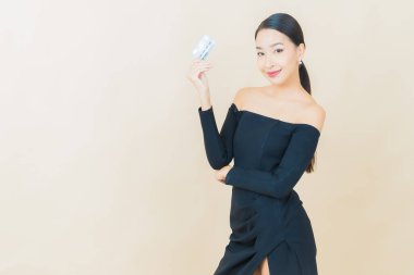 Güzel bir Asyalı kadının portresi. Renkli kredi kartıyla gülüyor.