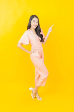 Portre güzel Asyalı kadın gülümsüyor. Renkli arka planda hareket var.