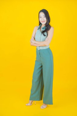 Portre güzel Asyalı kadın gülümsüyor. Renkli arka planda hareket var.