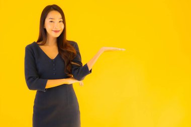 İzole edilmiş sarı arka planda hareketli güzel Asyalı kadın portresi.