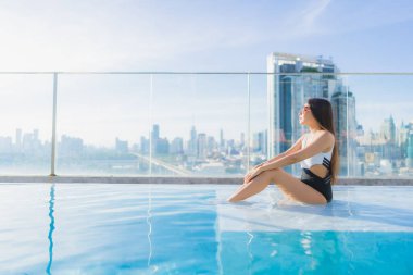 Güzel bir Asyalı kadının portresi tatil gezilerinde yüzme havuzunda rahatlar.