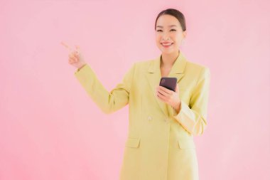 Güzel Asyalı iş kadını portresi. Arka planda kahve fincanı ve akıllı cep telefonu kullanıyor.