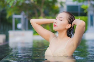 Güzel bir Asyalı kadın portresi. Rahatlayın. Yüzme havuzu etrafında gülümseyin.