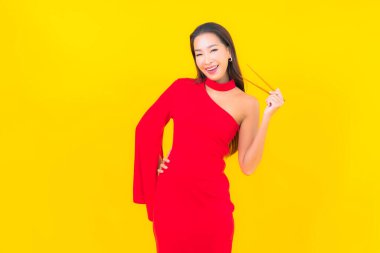 Sarı arka planda yemek yemeye hazır Asyalı güzel bir kadın portresi.