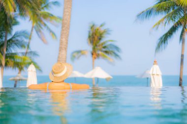 Güzel bir Asyalı kadın portresi. Rahatlayın. Yüzme havuzunun, deniz kenarındaki okyanus manzarasının keyfini çıkarın.