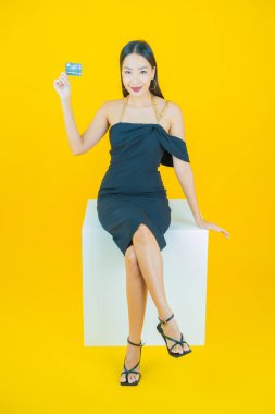 Güzel bir Asyalı kadının portresi. Renkli kredi kartıyla gülüyor.