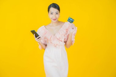 Güzel bir Asyalı kadının portresi. Renkli kredi kartıyla gülüyor.