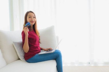 İnternetten alışveriş yapmak için cep telefonu ve kredi kartı kullanan Asyalı güzel kadınların portresi.