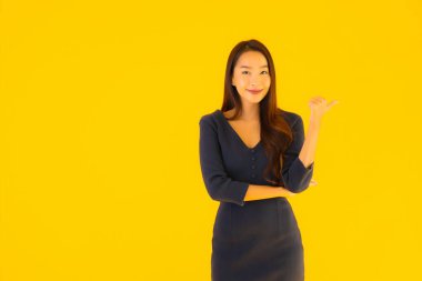 İzole edilmiş sarı arka planda hareketli güzel Asyalı kadın portresi.