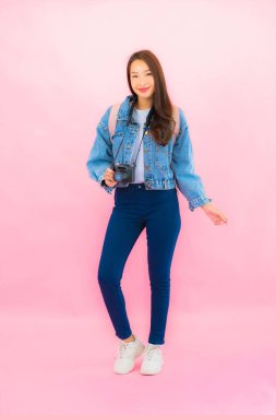 Portrait beautiful young asian woman backpack or luggage with camera ready for travel in vacation on pink background