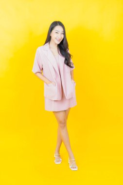 Portre güzel Asyalı kadın gülümsüyor. Renkli arka planda hareket var.