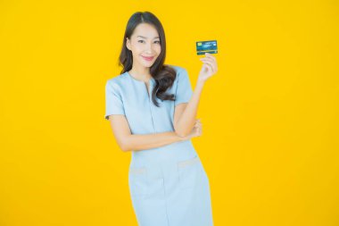 Güzel bir Asyalı kadının portresi. Renkli kredi kartıyla gülüyor.