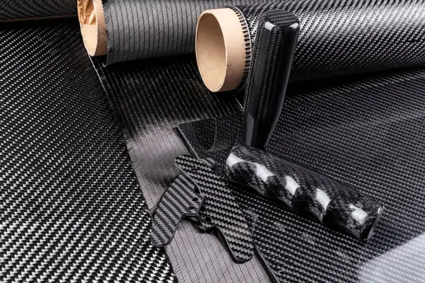 stock image lightweight carbon fiber tuning parts and CFK sheet on composite  raw material cloth.  automotive and car racing  industry and high tech background.