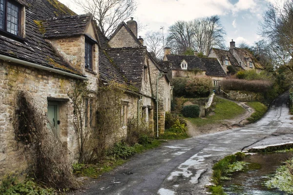 A row of stone cottages / houses in a typical rural village in the touristic Cotswolds region of England, UK with no people