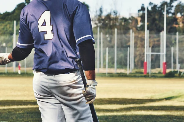 棒球手拿着球棒在运动场上穿着队服的后视镜 — 图库照片