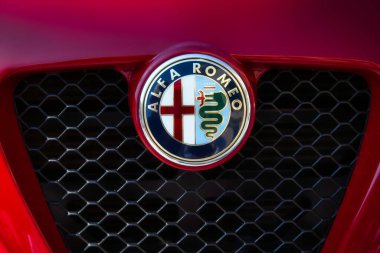 Klasik bir spor arabanın ön radyatör ızgarasında Alfa Romeo marka logosu yakın çekim.