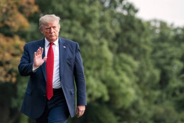 Washington DC, ABD - 21 Ağustos 2019: Ciddi görünümlü bir başkan Donald Trump Beyaz Saray 'ın çimlerinde elini sallayarak selamlıyor.