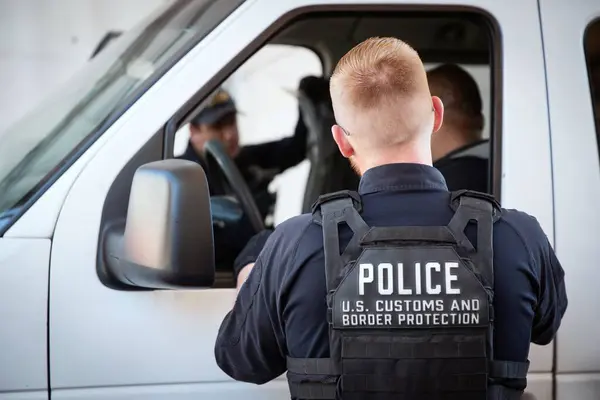 stock image Nogales, Arizona, USA - June 11 2024: A U.S. Customs and Border Protection officer inspecting a white van