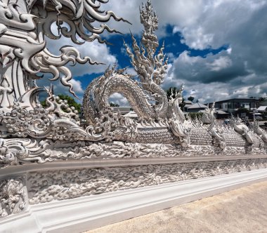 Chiang Rai 'de Wat rong Khun' un önünde dekoratif ejderhalar