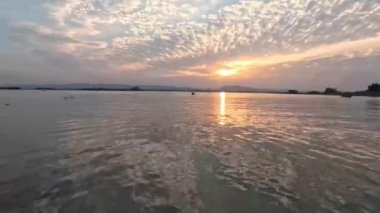Kaptai gölünün arka planında gün batımı ufuk su ve bulutları aydınlatıyor.