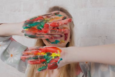 Talented Female Artist smiling happy showing colorful painted hands. Colorful, Emotional, Sensual Painter Creating Abstract Modern Art. Creative Expression concept.