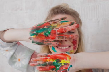 Talented Female Artist smiling happy showing colorful painted hands. Colorful, Emotional, Sensual Painter Creating Abstract Modern Art. Creative Expression concept.