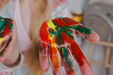 Talented Female Artist showing colorful painted hands. Colorful, Emotional, Sensual Painter Creating Abstract Modern Art. Creative Expression concept.
