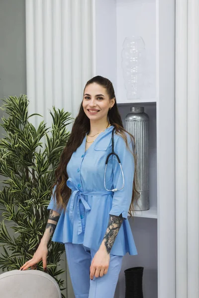 The cosmetic dermatologist is standing with a warm and welcoming smile, putting patients at ease and creating a comfortable atmosphere in her workspace.
