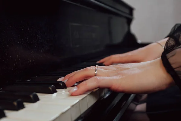 Close up of woman\'s hands playing piano.