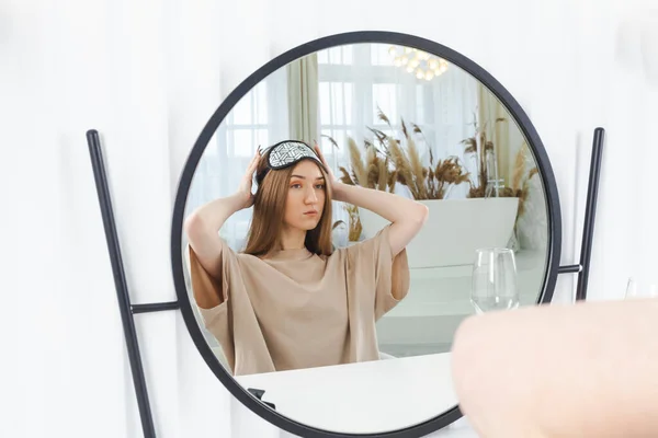 可愛いブルネットの女の子が鏡の前に座って化粧をしている 鏡の反射に注目してください セルフケアと美しさの概念 — ストック写真