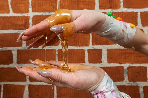 付属のキャンディーで飾られ 粘着性の蜂蜜で覆われたマニキュア爪で女性の手のクローズアップ 砂糖やお菓子糖尿病不健康な食べ物砂糖ラッシュの概念 — ストック写真