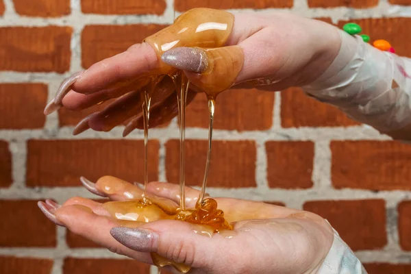付属のキャンディーで飾られ 粘着性の蜂蜜で覆われたマニキュア爪で女性の手のクローズアップ 砂糖やお菓子糖尿病不健康な食べ物砂糖ラッシュの概念 — ストック写真