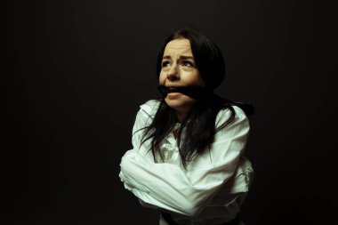 Psikiyatri hastanesinde siyah izole edilmiş bir arka planda, deli gömleği giymiş, akıl hastası ve deli gömleği giymiş bir kadın. Zihinsel bozukluklar konsepti. Çılgın hapishane..