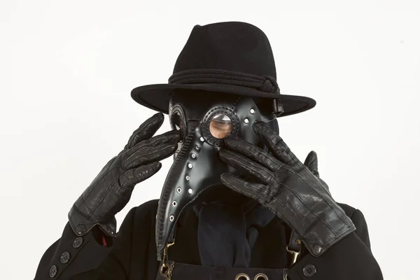 Close-up Portrait of a plague doctor from Medieval era. high-quality, detailed costume with a hat, leather mask, apron, and long coat. Isolated on a white background. epidemic and pandemic concept.