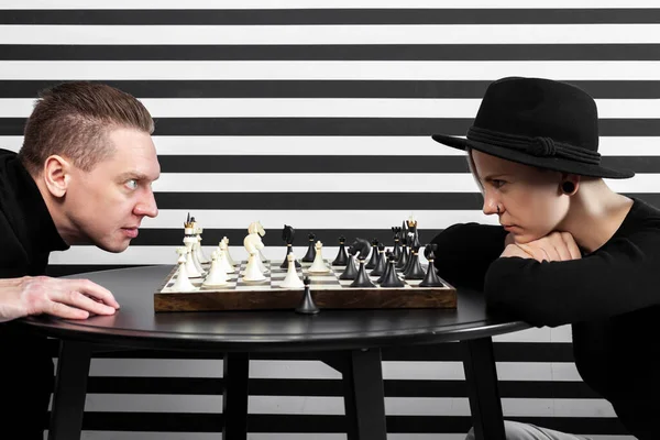 女と男がチェスをし 鋭い視線で見つめ合う 心理的圧力とか戦争とか不公平な遊びとか — ストック写真