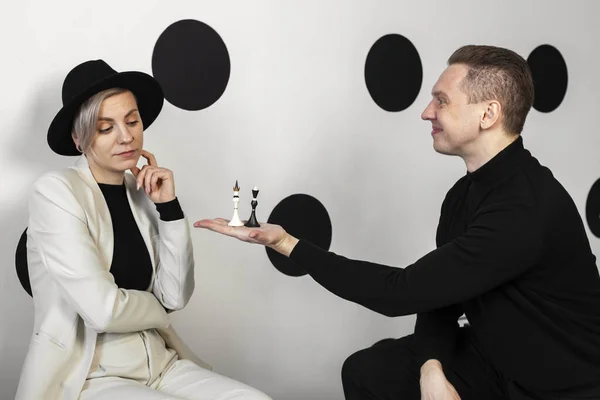 手に黒と白のチェスの駒を持っています 女性を提供します — ストック写真