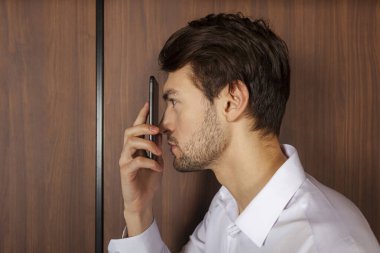 Genç bir adam telefonuna çok yakından bakıyor. Telefonunda yaşıyor. Gözlerim iyi görmüyor. Miyopluk. Modern toplumun sorunları.