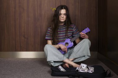Asansörde gitar çalıp bahşiş toplayan uzun saçlı tatlı bir hippi kızın portresi..