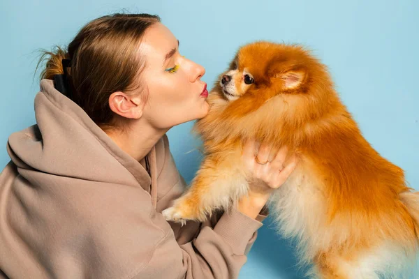 Привлекательная Молодая Девушка Целует Свою Очаровательную Померанскую Собаку Шпица Изолированный — стоковое фото