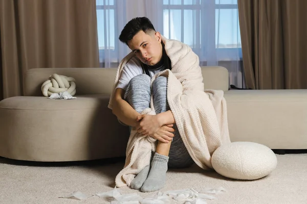 Jovem Está Sentado Lado Sofá Envolto Cobertor Está Doente Com — Fotografia de Stock