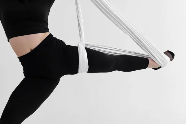 黒のタイツを着た女性の足のクローズアップは 空のシルクやファブリックを使用した倒立型の反重力空中ヨガを実行します 物理的および精神的な努力の間のバランス 白に隔離された — ストック写真