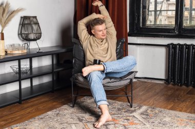 Tembel bir sabah. İşini bitirdikten sonra evdeki rahat koltukta dinlenen adam mutlu bir gülümsemeyle yan yana bakıyor. Sakin bir genç hafta sonundan zevk alıyor. Huzurlu rüyaların tadını çıkarıyor.