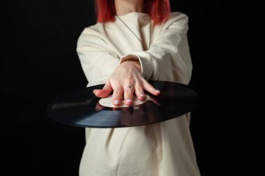 Beyaz, büyük kazaklı, mutlu, kızıl saçlı bir kızın plakla bir rekoru var. Siyah üzerine izole edilmiş..