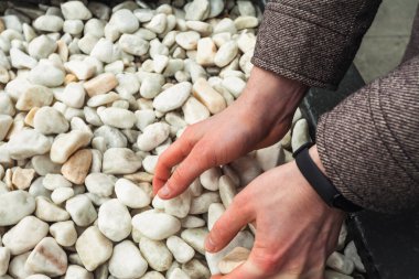 El ele tutuşup kuvars çakıl taşlarını toplayın. Beyaz pürüzsüz dekoratif taşlar.