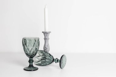 Klasik cam bardaklar ve beyaz bir mum..