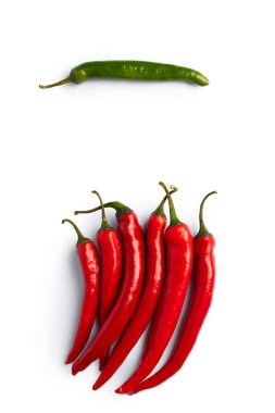 Kırmızı ve yeşil biberin bileşimi, bir tanesi göze çarpıyor. Beyaz arka planda izole edilmiş. Düz yatış, üst görünüm.