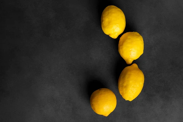 stock image Fresh, bright yellow lemons isolated on a black, dark gray background with a copy space. flat lay, top view.