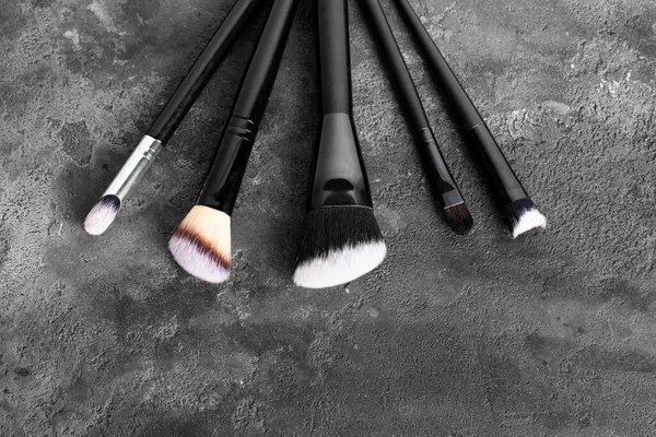 メイクブラシ 化粧品 濃い灰色の斑点の背景の化粧道具のセット フラット レイトップ ビュー — ストック写真