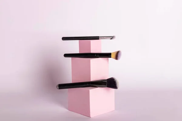 粉红立柱上摆放的一套化妆品刷 — 图库照片