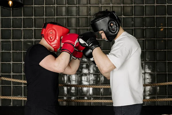 两个大个子拳击手头戴头盔和手套在拳击场上打斗 — 图库照片